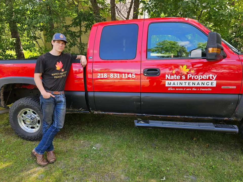 Team member beside a red Nate’s Property Maintenance pickup truck
